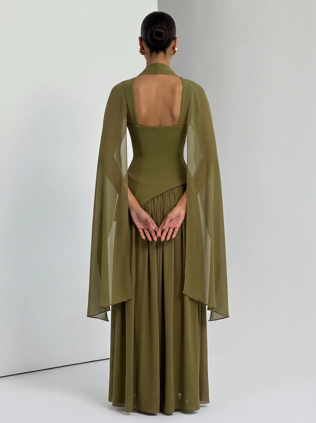 Mujer con estola de chifón oliva Aina™ para una boda, vista de espalda