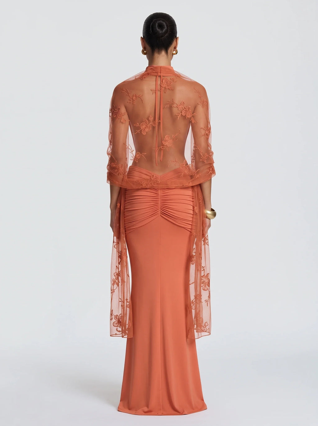 Mujer con estola de tul bordado naranja Pía™ para una boda, vista de espalda